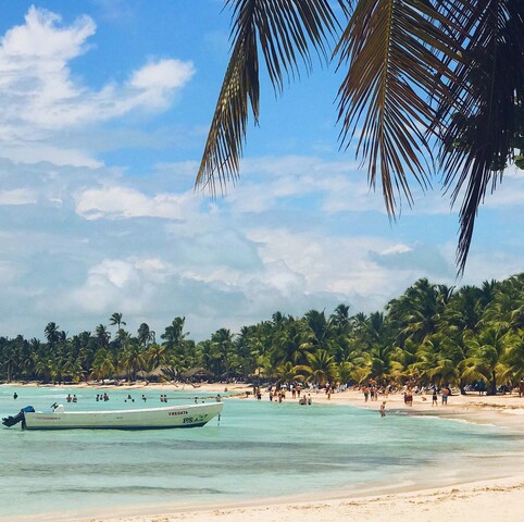 people-walk-golden-beach-with-palms-before-turquoise-water